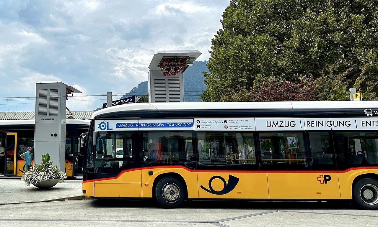 Ein Elektro-PostAuto an einer modernen Schnellladestation.